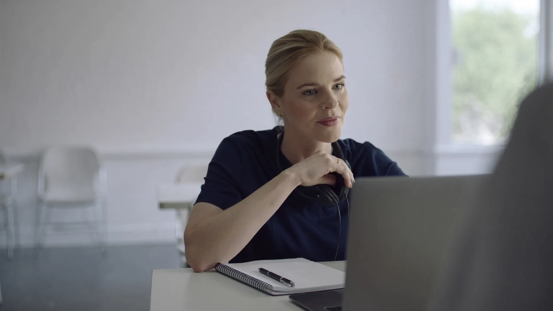 A nurse practitioner watching a training video on a laptop
